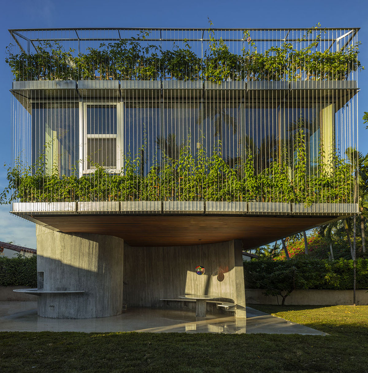 Sun Path House is a sculptural concrete house that dialogs with old bungalow houses