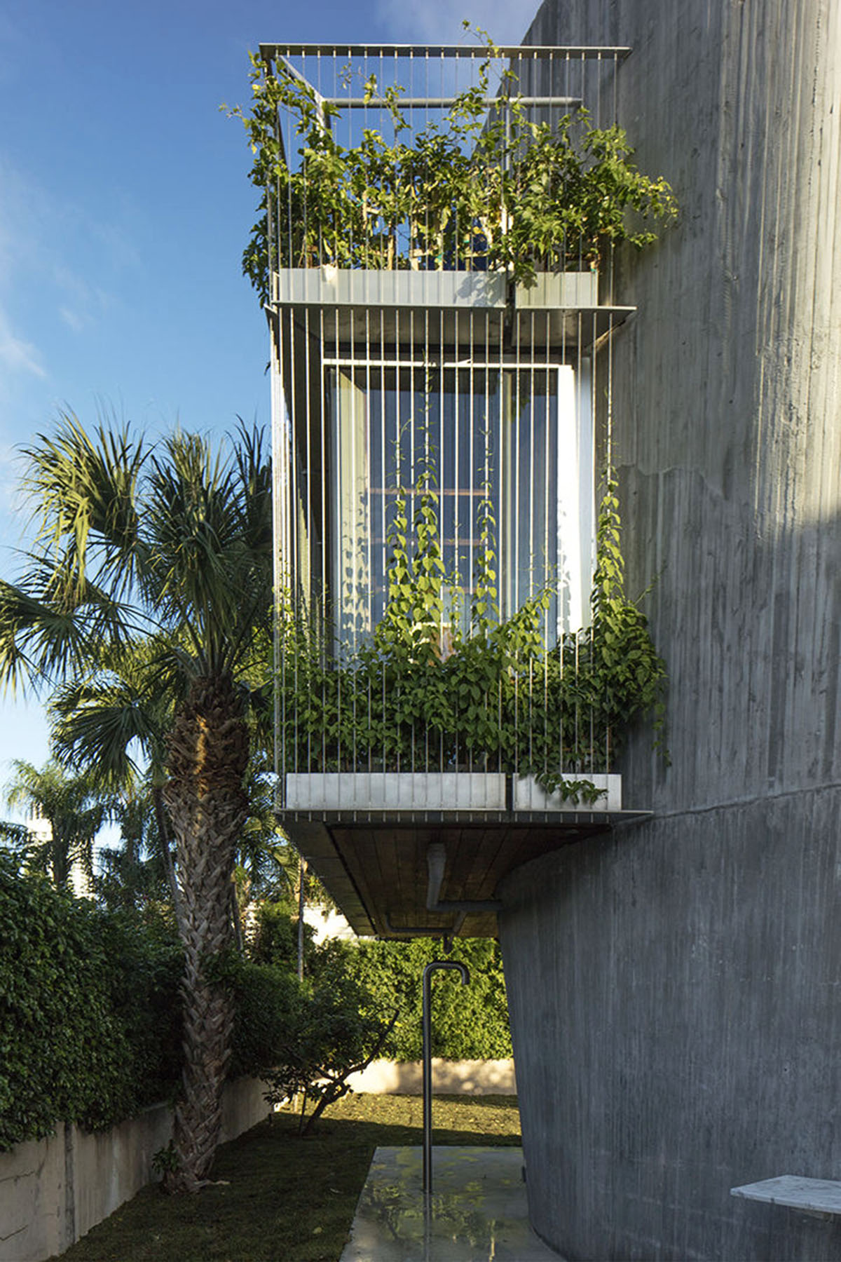 Sun Path House is a sculptural concrete house that dialogs with old bungalow houses