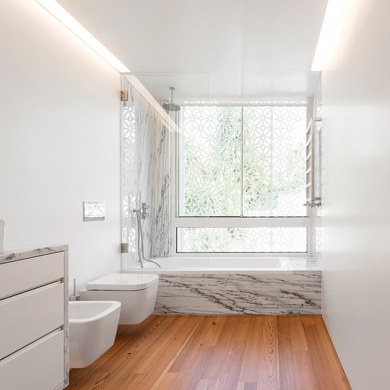 Restelo III House in Lisbon is wrapped by a white metallic fascia filtering sun light