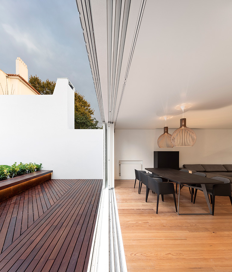 Restelo III House in Lisbon is wrapped by a white metallic fascia filtering sun light