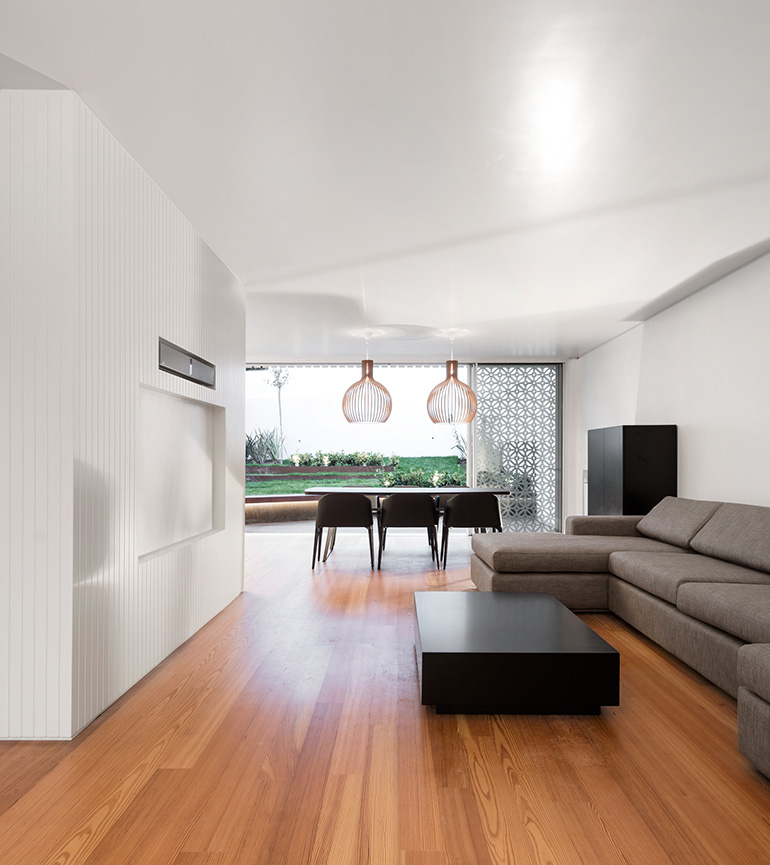 Restelo III House in Lisbon is wrapped by a white metallic fascia filtering sun light