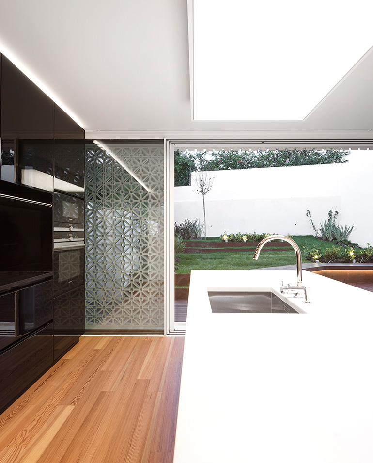 Restelo III House in Lisbon is wrapped by a white metallic fascia filtering sun light