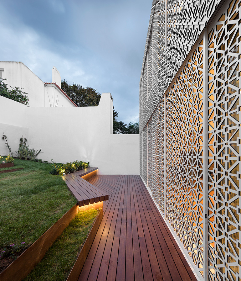 Restelo III House in Lisbon is wrapped by a white metallic fascia filtering sun light