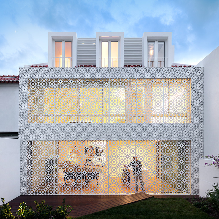 Restelo III House in Lisbon is wrapped by a white metallic fascia filtering sun light