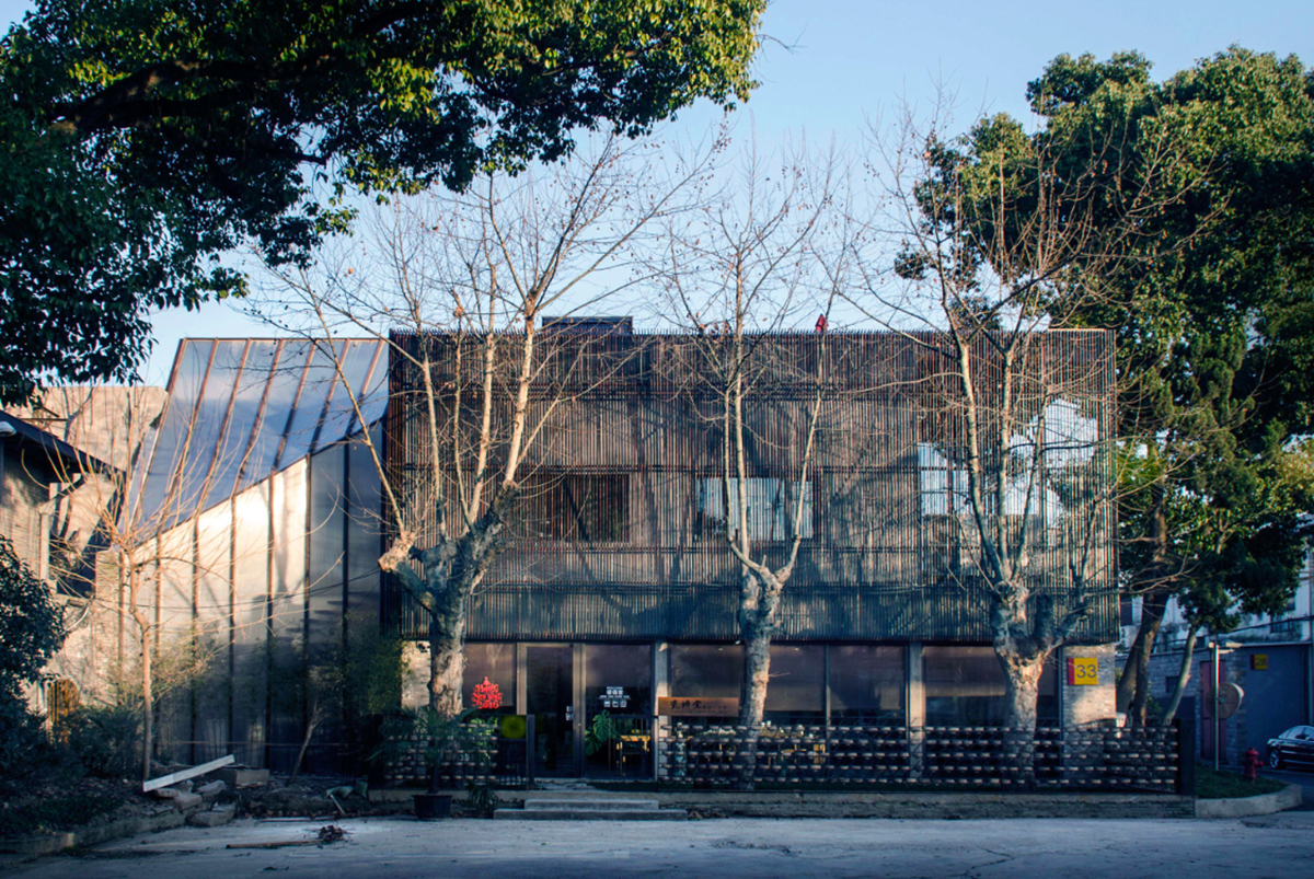 A red cedar grill placed on mottled worn walls of Ceramic House to preserve authenticity