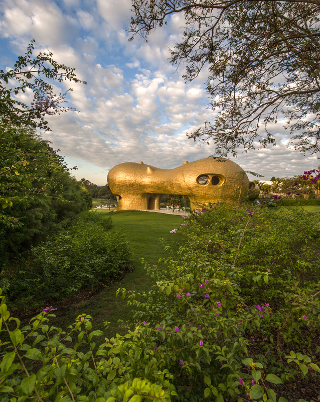 Javier Senosiain&rsquo;s Amoeba House supported on three legs and painted with gold+copper patina