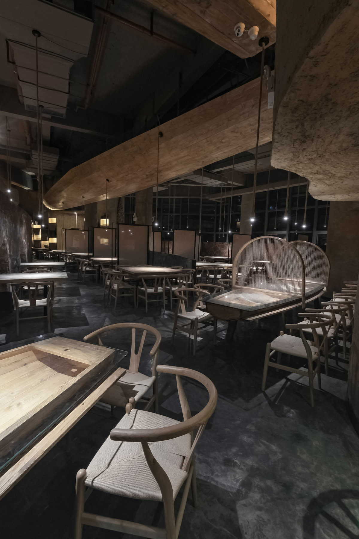 Designer Xu Xu-Jun hangs plenty of wooden-boats from the ceiling of Pu Zao Restaurant in China