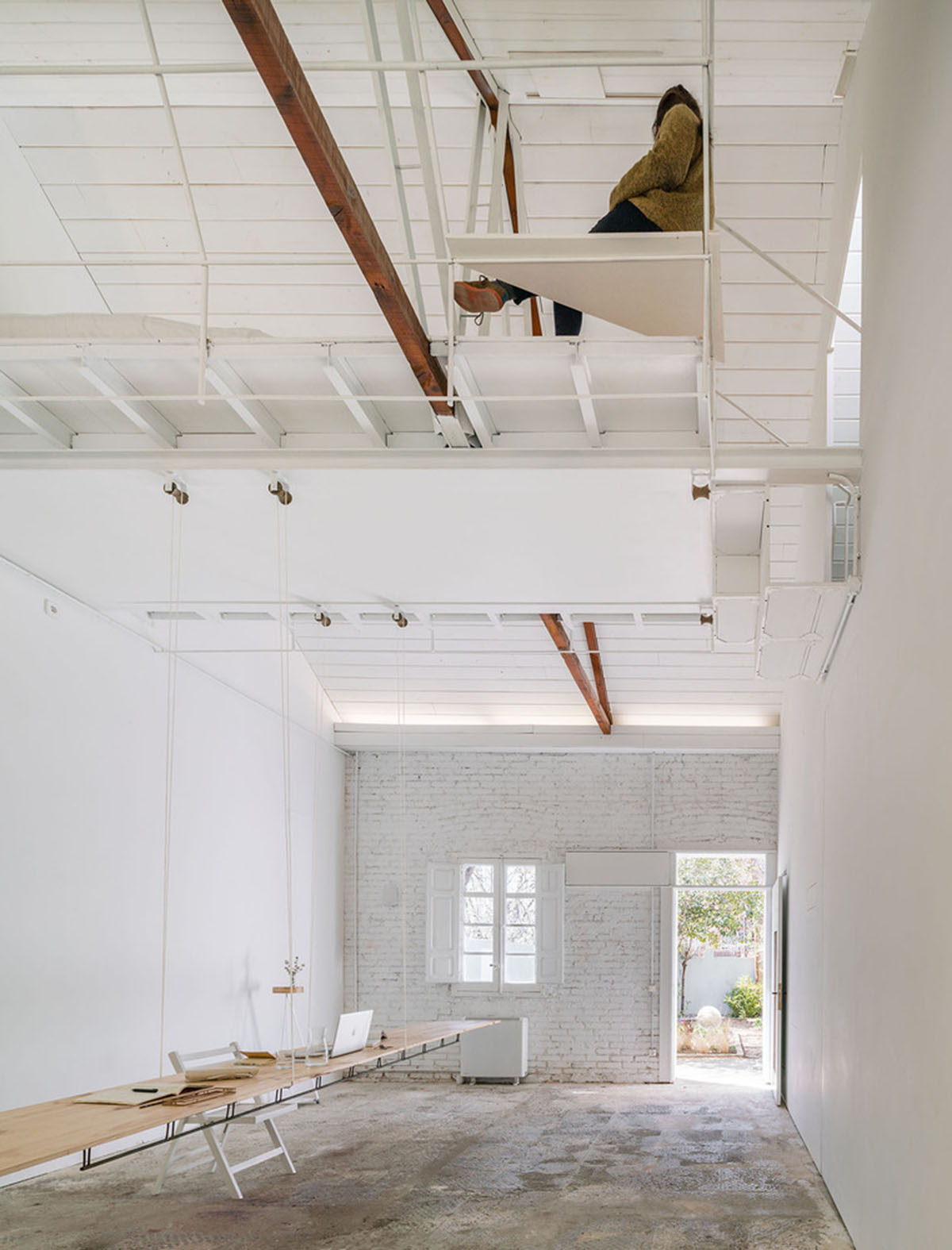 Pía Mendaro converts old house into an artist residence with floating mezzanine floor in Madrid