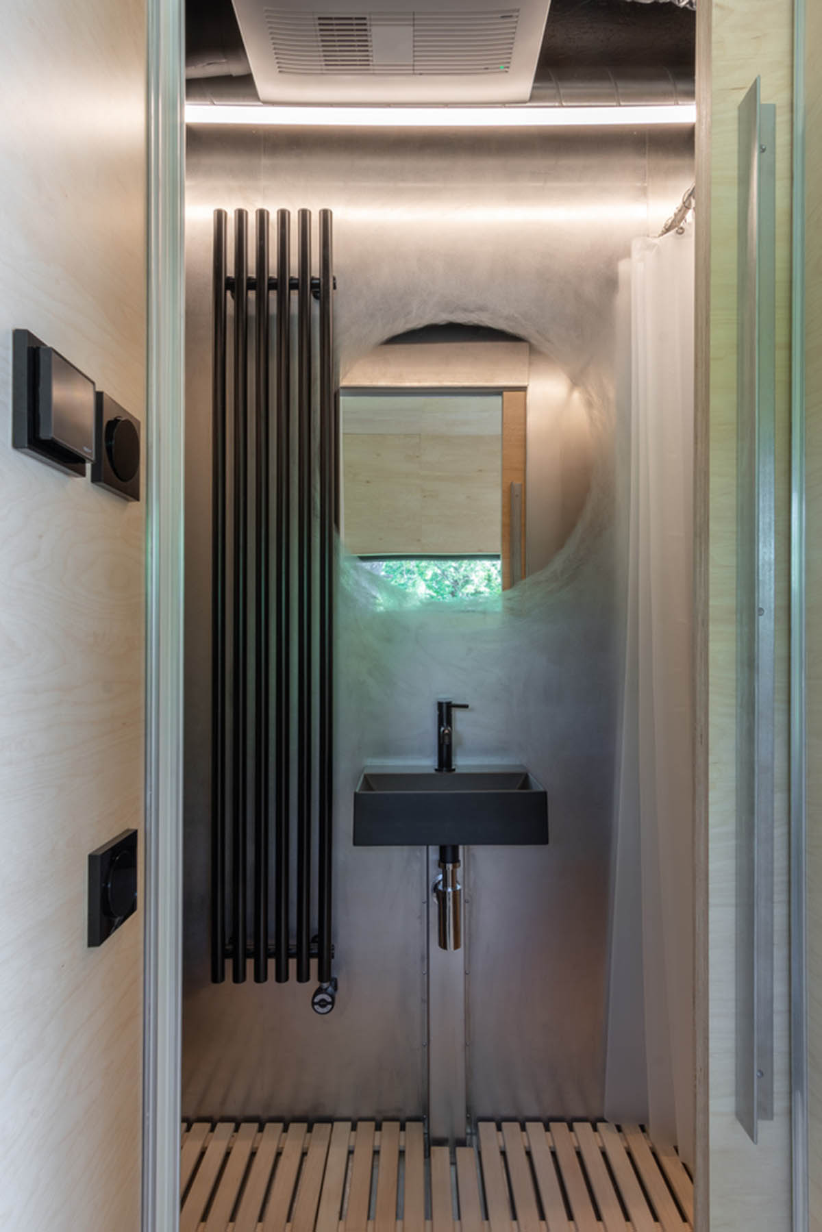 ŠA atelier designs linear black metal cabin to frame the view on natural terrain of Lithuania