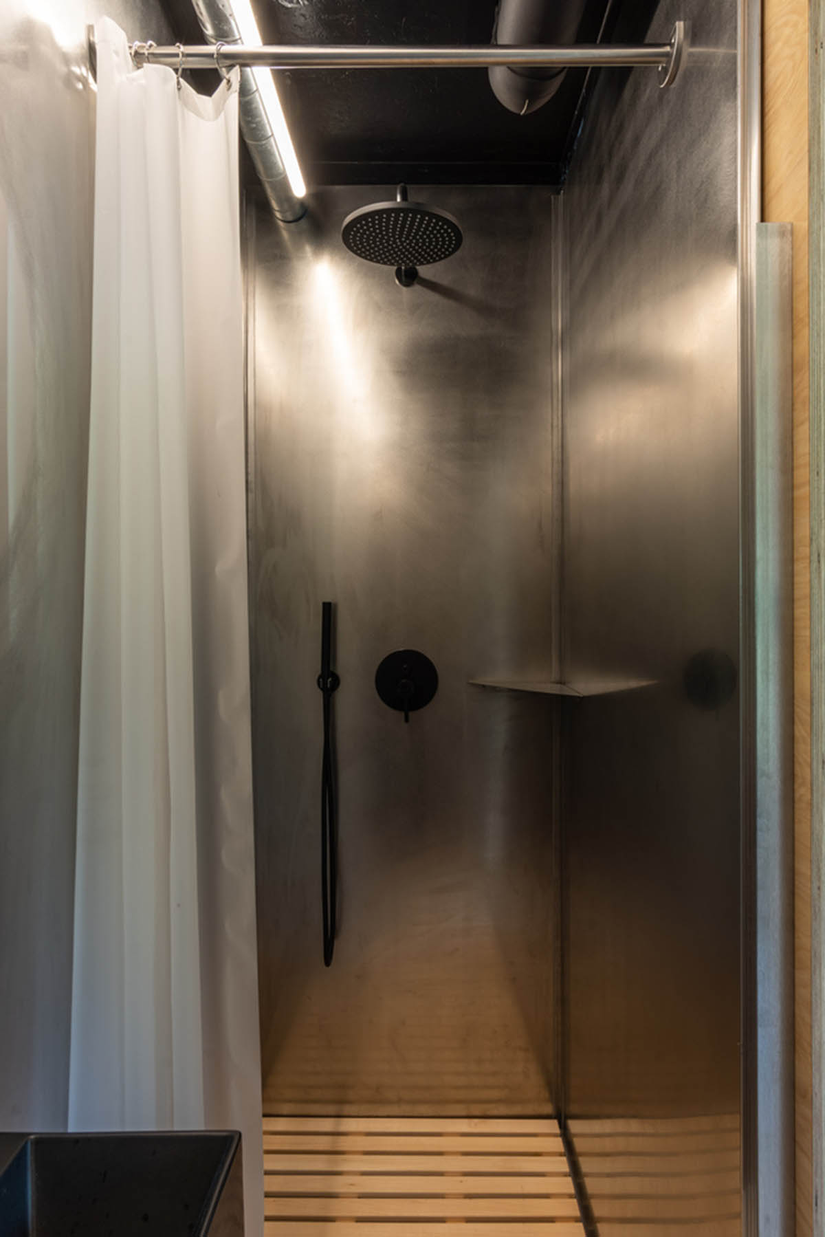 ŠA atelier designs linear black metal cabin to frame the view on natural terrain of Lithuania