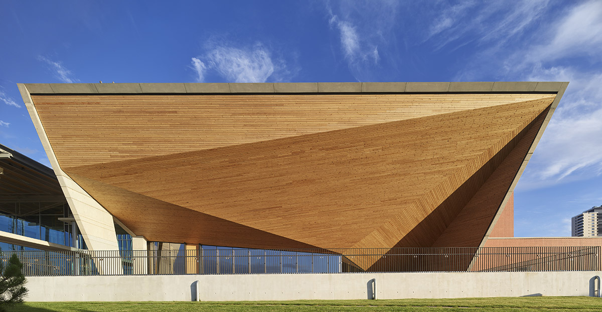 Uygur Architects articulates performing arts center façade with wooden triangulating surfaces