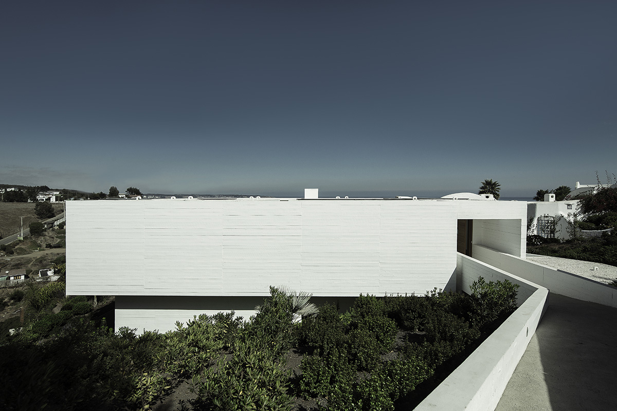 Cristián Romero Valente built this white concrete house on steep