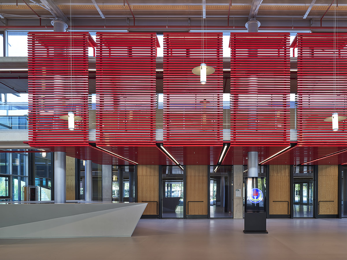 Uygur Architects articulates performing arts center façade with wooden triangulating surfaces