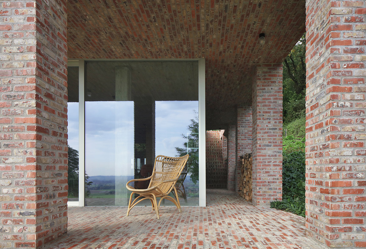 Studio Okami Architects built brick private villa embedded in the slope to offer infinite views