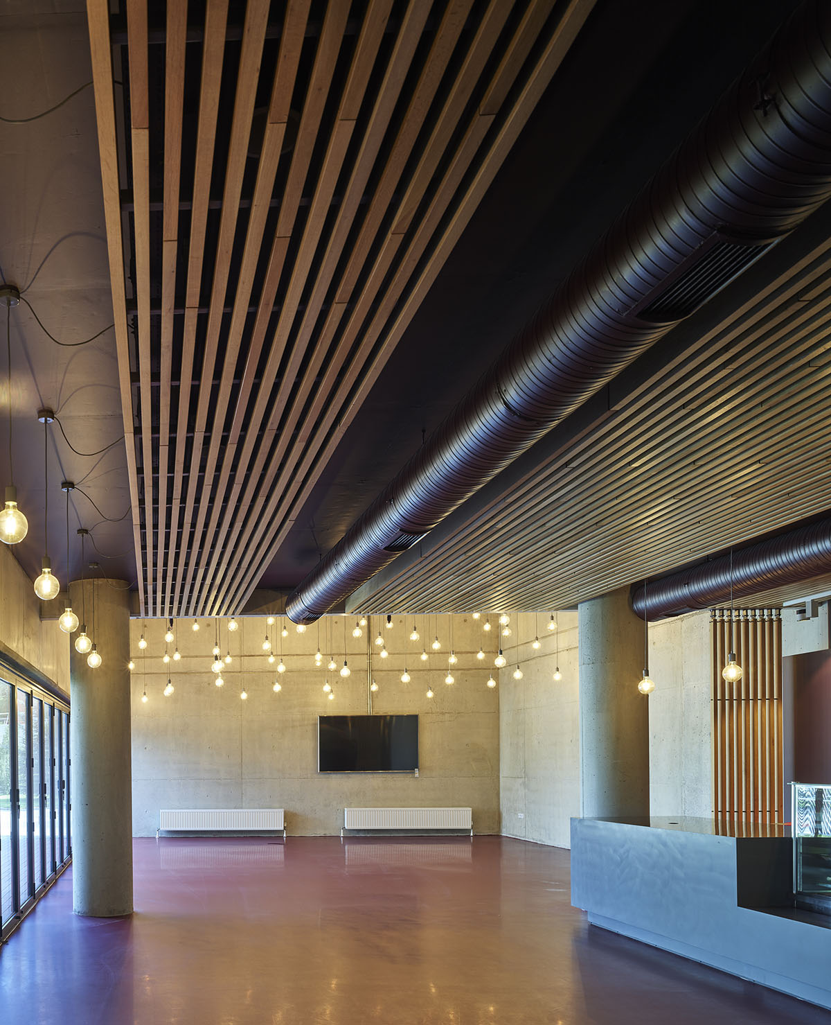 Uygur Architects articulates performing arts center façade with wooden triangulating surfaces