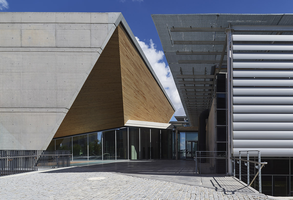 Uygur Architects articulates performing arts center façade with wooden triangulating surfaces