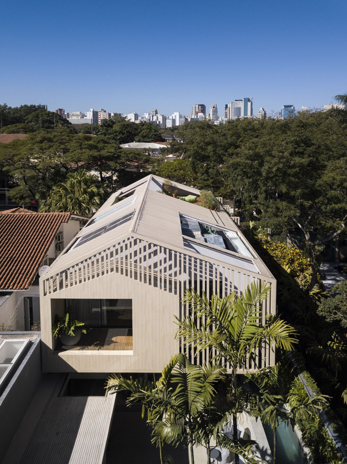 Studio AG designed large wooden residence featuring punctured volumes with gabled roof in São Paulo
