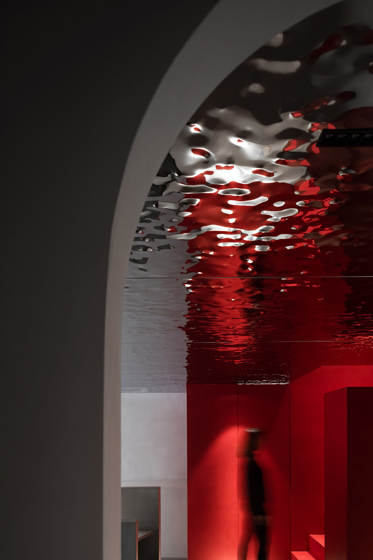 Grey and red colours combined with geometric shapes and shimmering ceiling for fashion store in China