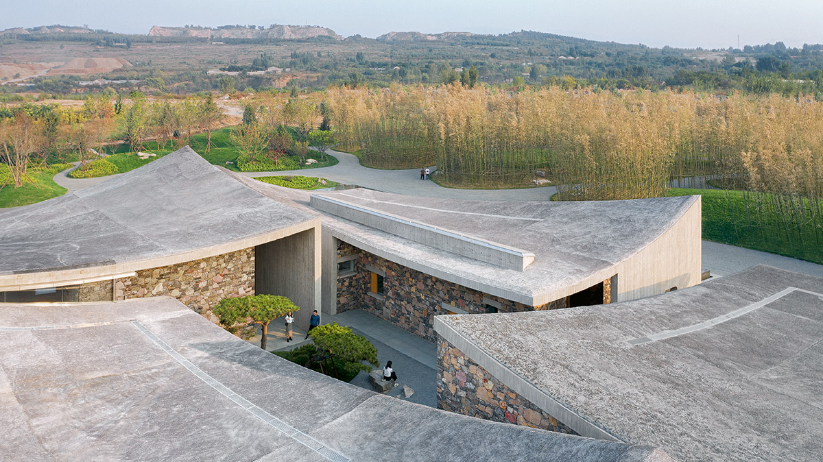 Concrete hyperboloid roofs cover masonry stone art center