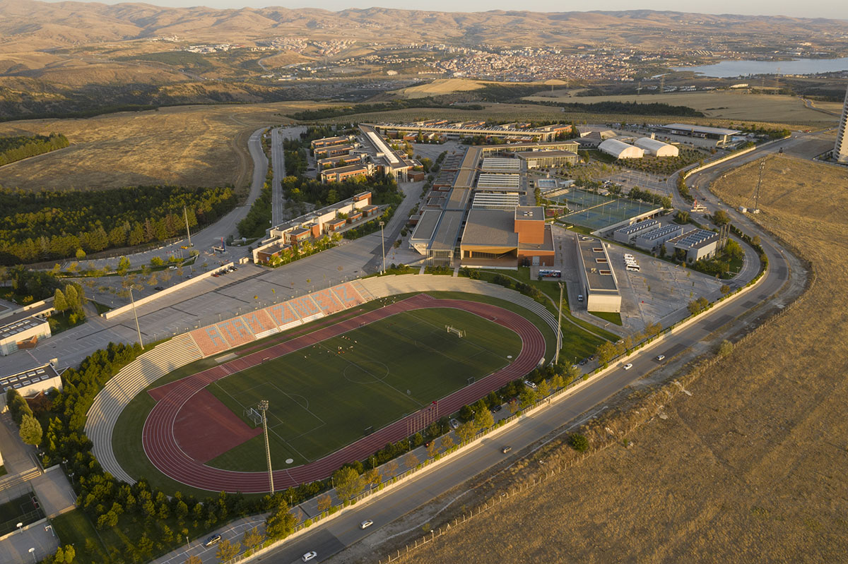 Uygur Architects articulates performing arts center façade with wooden triangulating surfaces