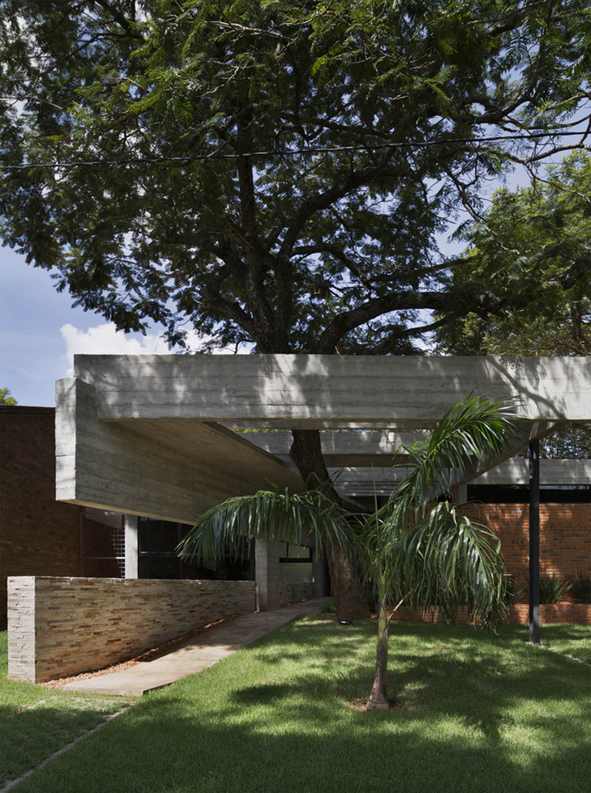 Concrete roof slabs and surfaces freely fly over this brick house in Paraguay by Culata Jovái Group