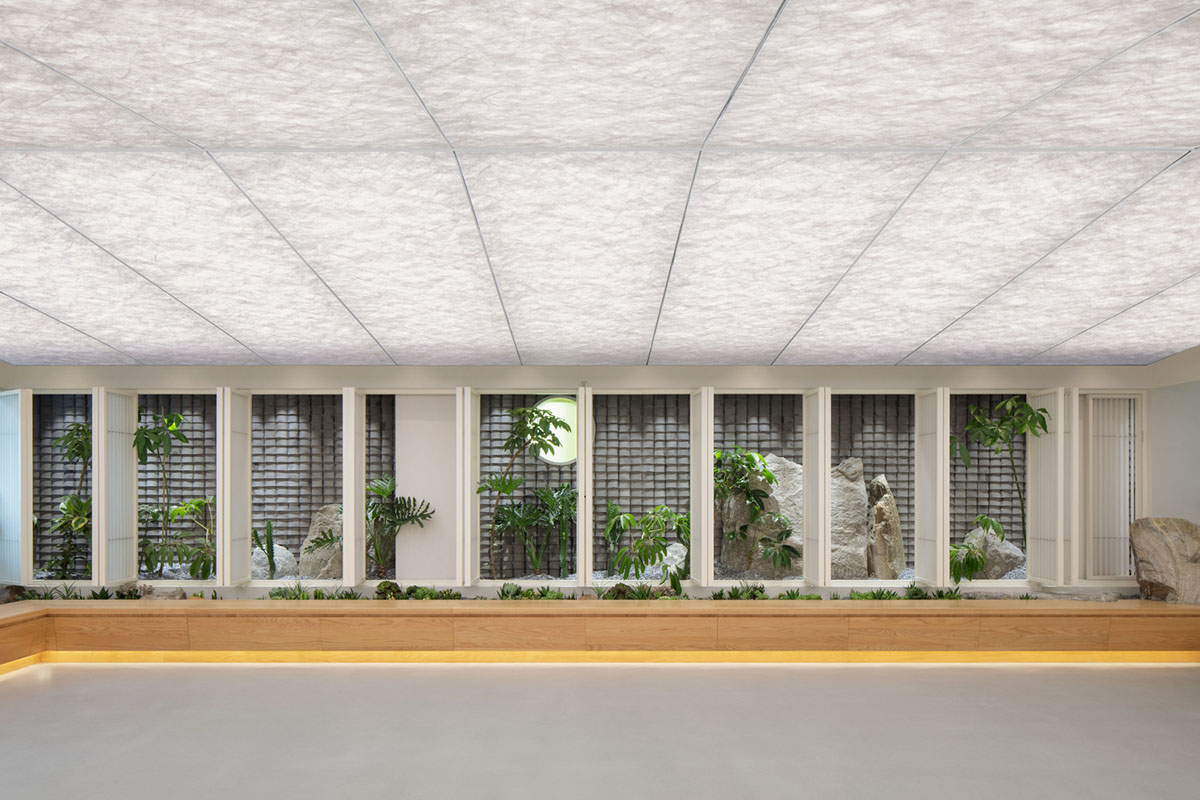 Jiejie studio wraps this tea room with a peach garden with rocky and forest landscape in Beijing