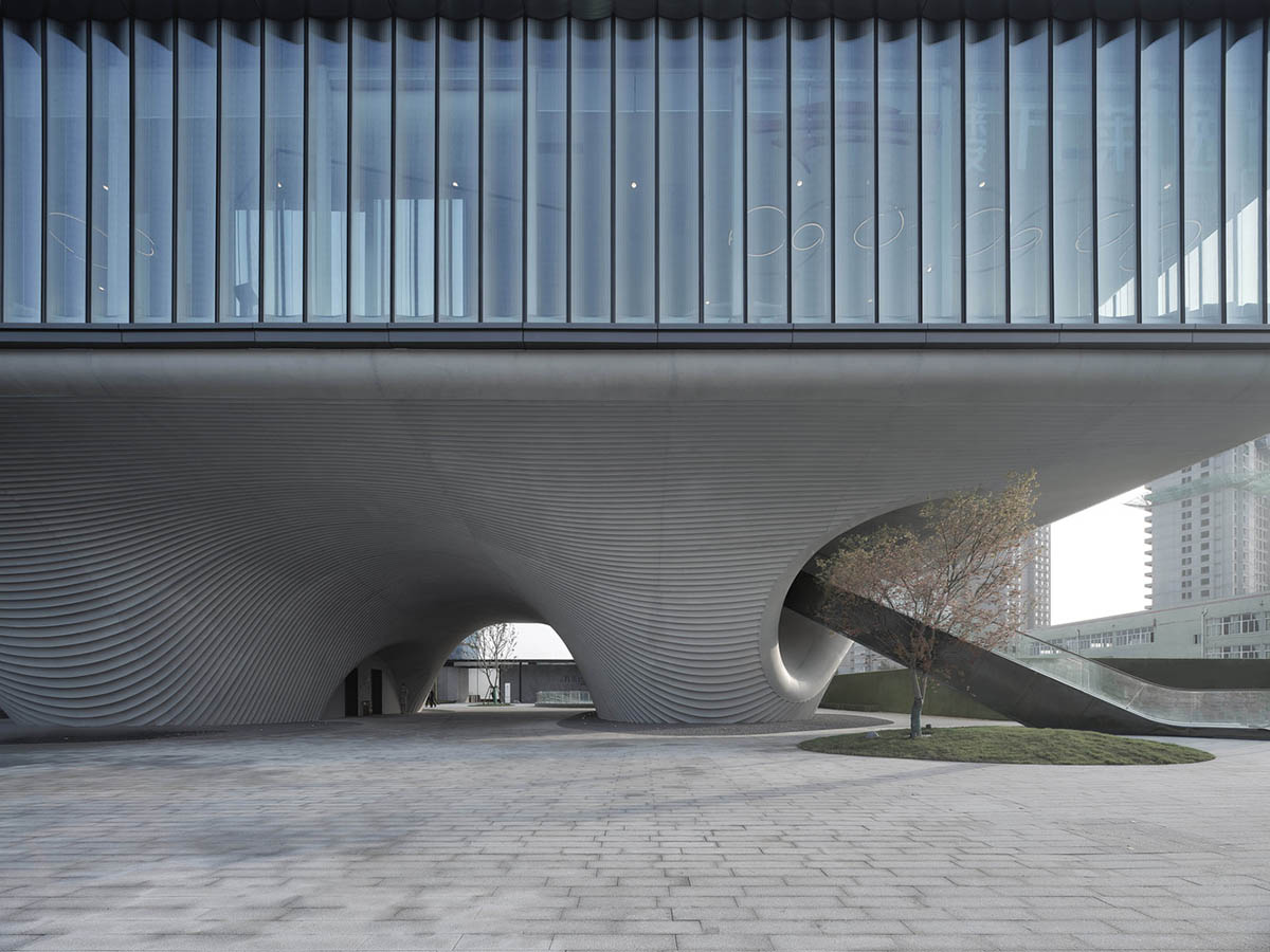 Community Center in Xi’an is raised on sculptural base that features a rippling effect