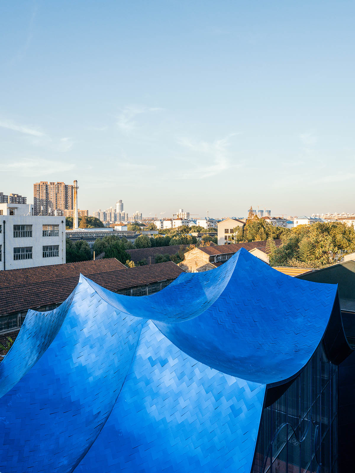 Wutopia Lab converts old roof-covered stockyard and duty room into wave-shaped community hub