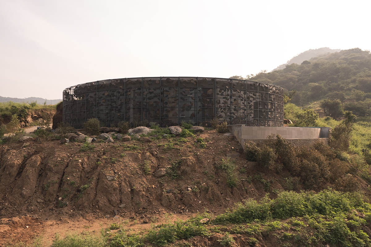 Farm house by Earthscape Studio is wrapped by gabion wall to filter light and airflow in India 