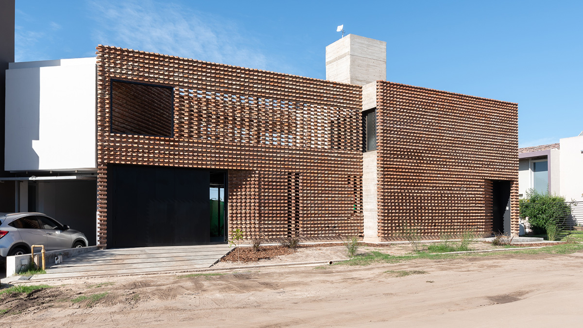 3D layer of brick wall wraps this family house to provide thermal comfort and special texture
