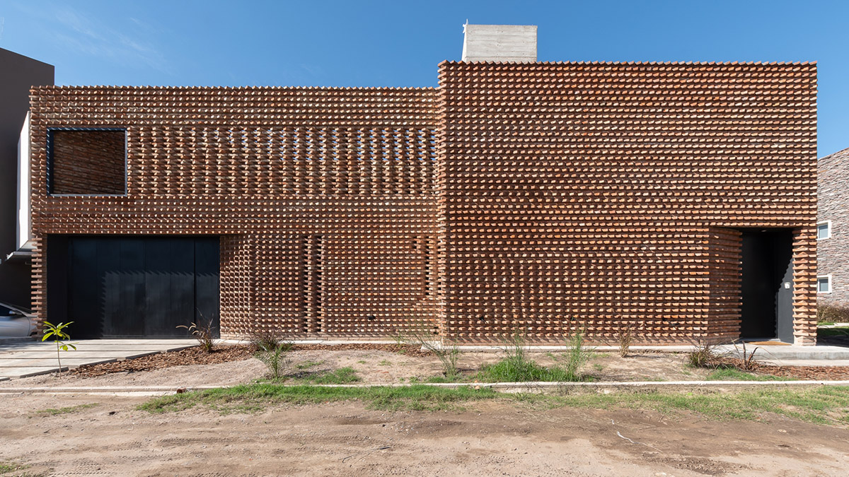 3D layer of brick wall wraps this family house to provide thermal comfort and special texture