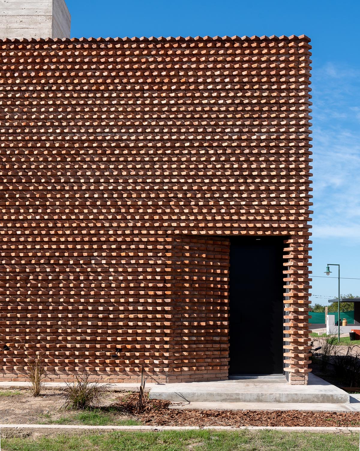 3D layer of brick wall wraps this family house to provide thermal comfort and special texture