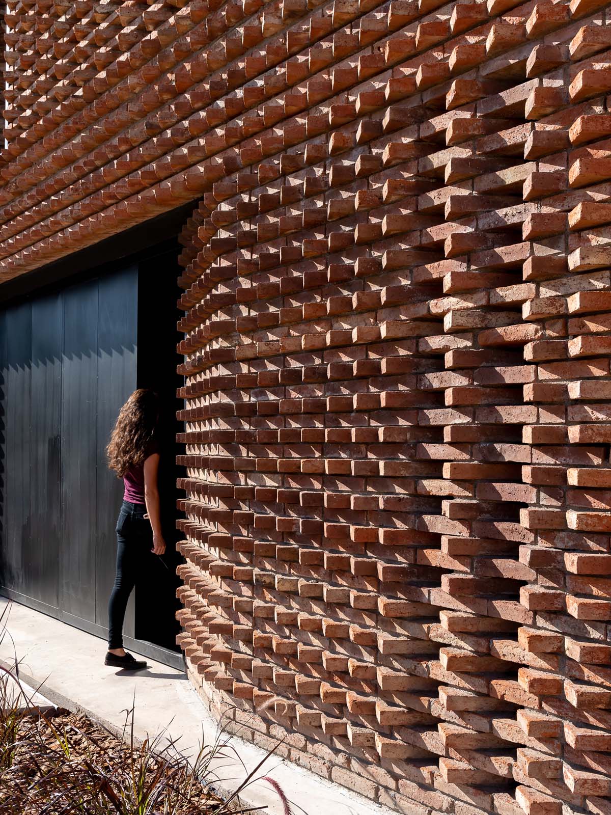 3D layer of brick wall wraps this family house to provide thermal comfort and special texture
