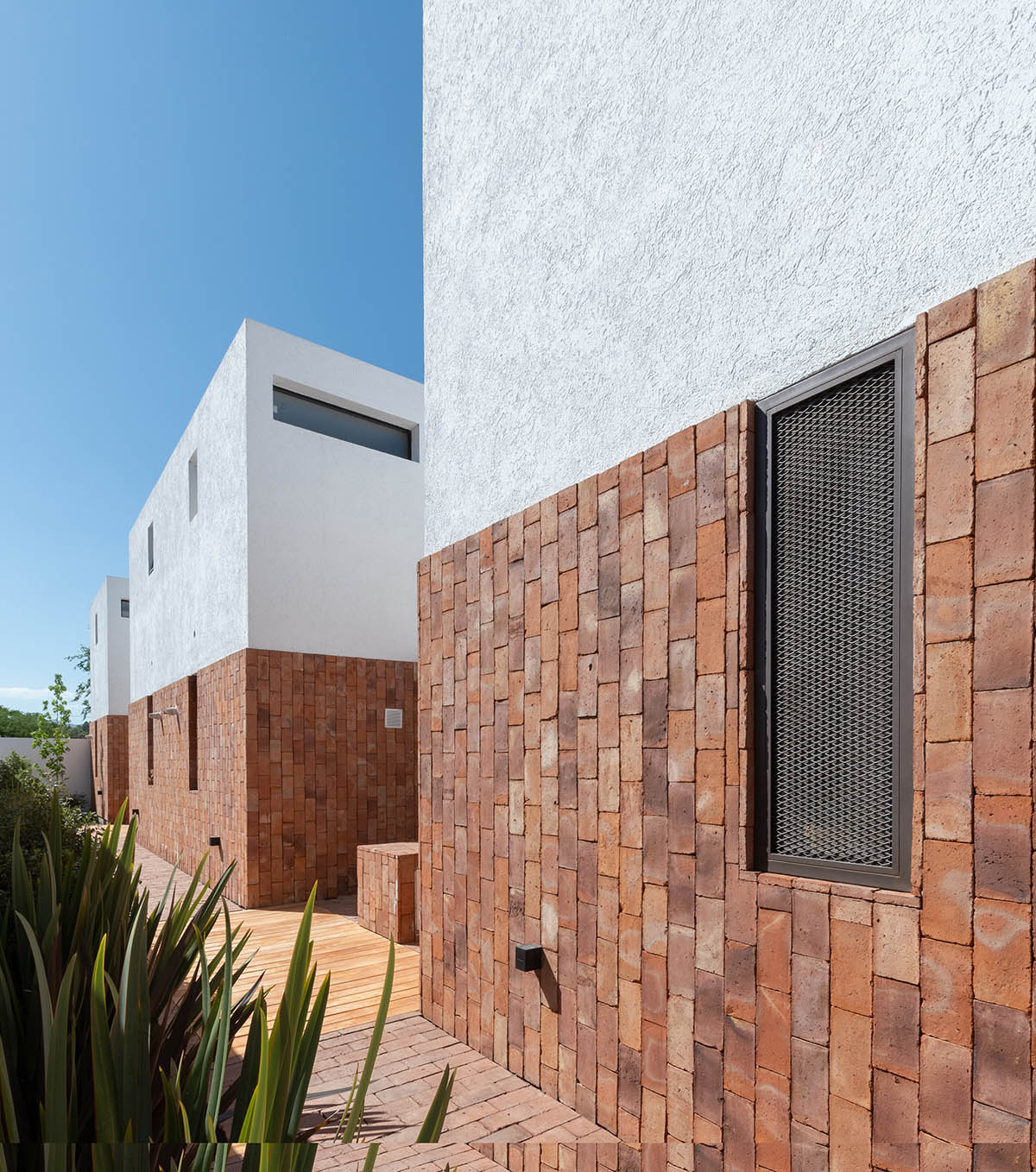 Andres Alonso Architecture Workshop completes La Inesita houses with tall brick base in Cordoba