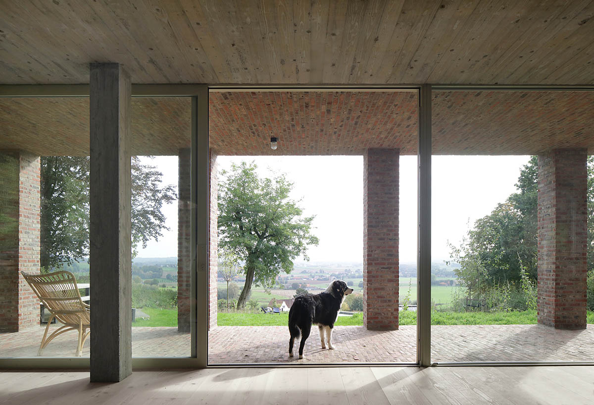 Studio Okami Architects built brick private villa embedded in the slope to offer infinite views