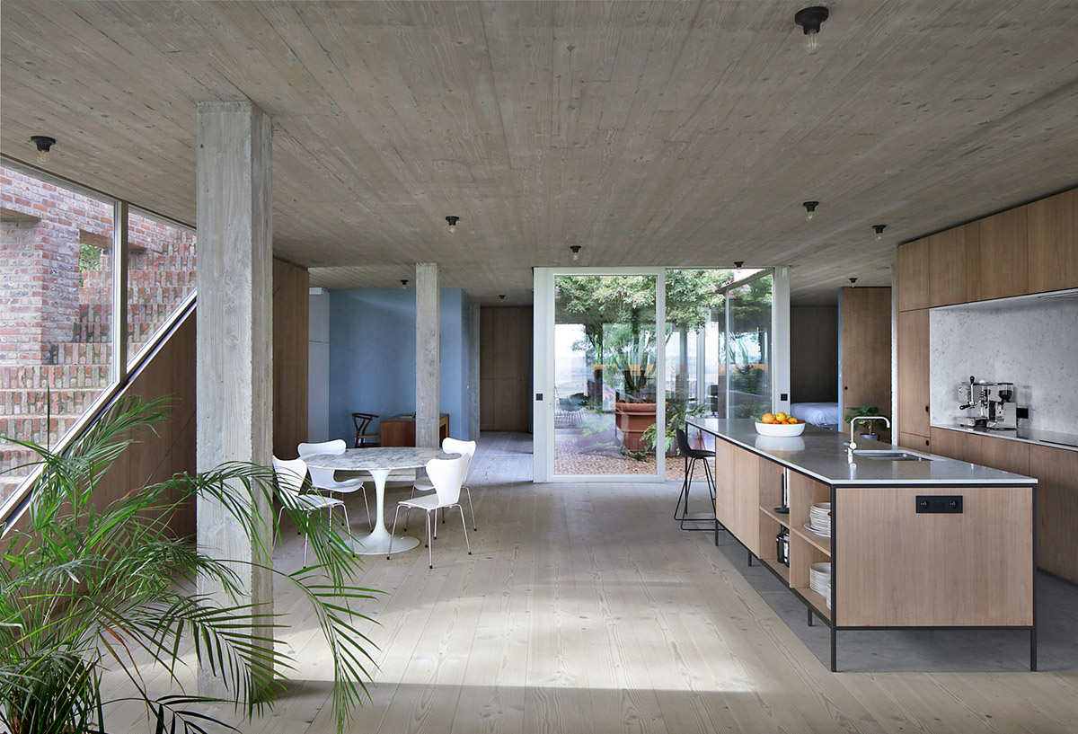 Studio Okami Architects built brick private villa embedded in the slope to offer infinite views