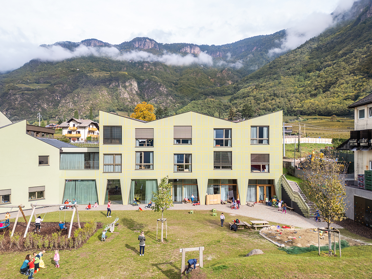 Zigzagged-profiled school featuring trapezoidal legs evokes traditional Tartan fabric in Terlano