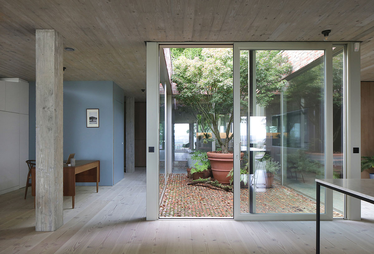 Studio Okami Architects built brick private villa embedded in the slope to offer infinite views