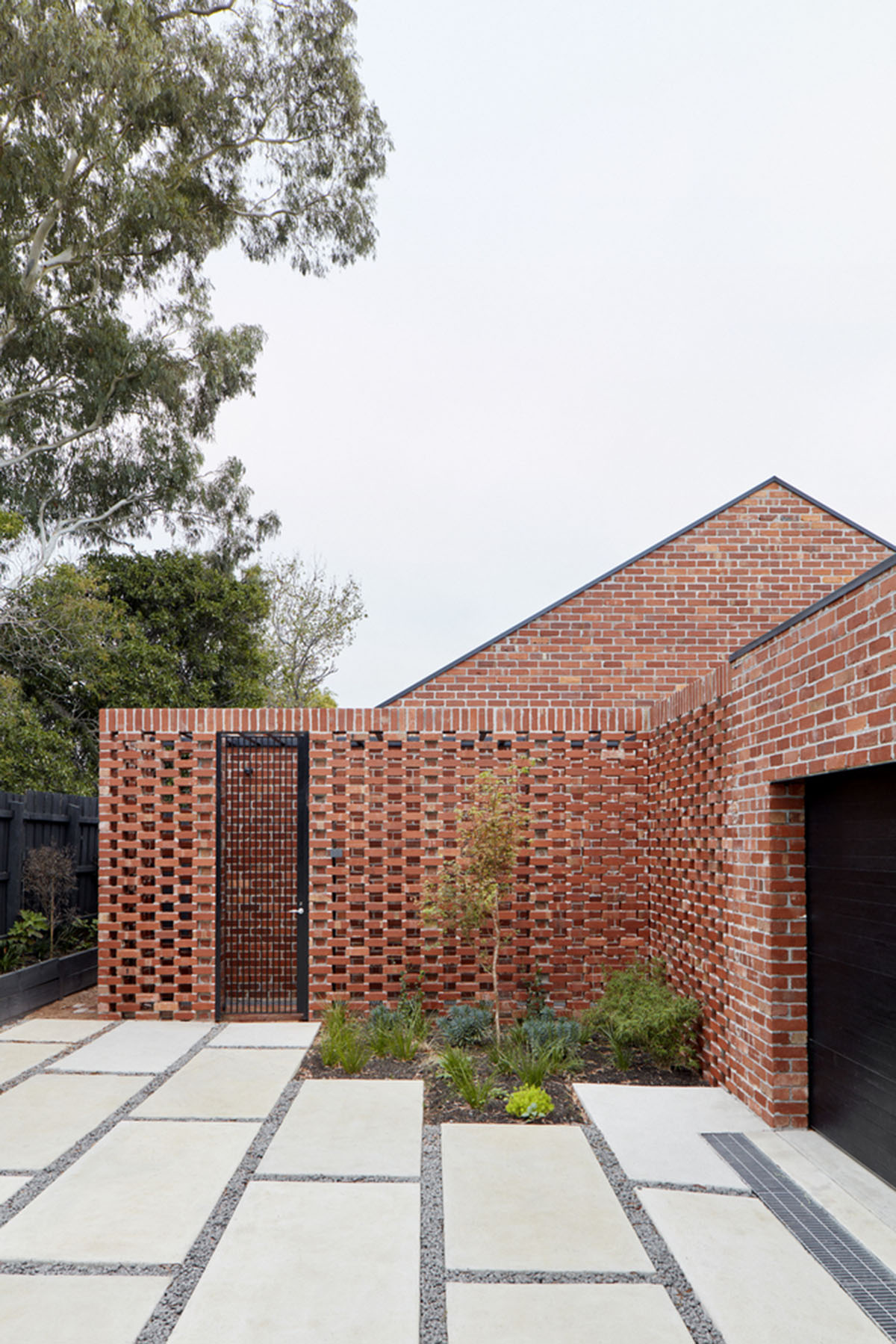 Recycled brick screens wrapping these two dwellings help thermal comfort in a suburb of Australia