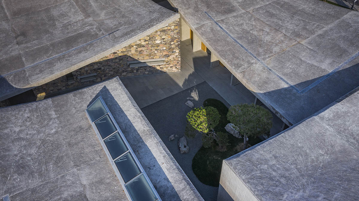 Concrete hyperboloid roofs cover masonry stone art center with a central courtyard in Shandong