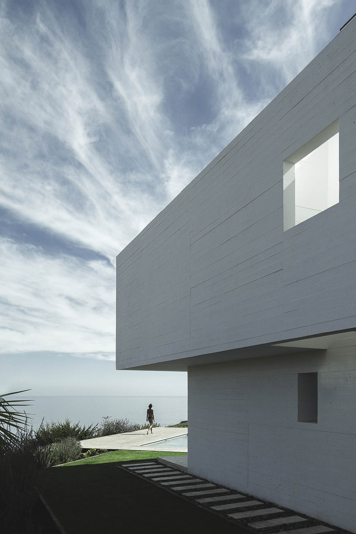 Cristián Romero Valente built this white concrete house on steep slope to give serene view in Chile