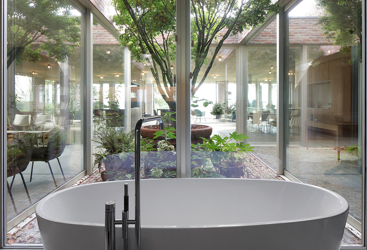 Studio Okami Architects built brick private villa embedded in the slope to offer infinite views