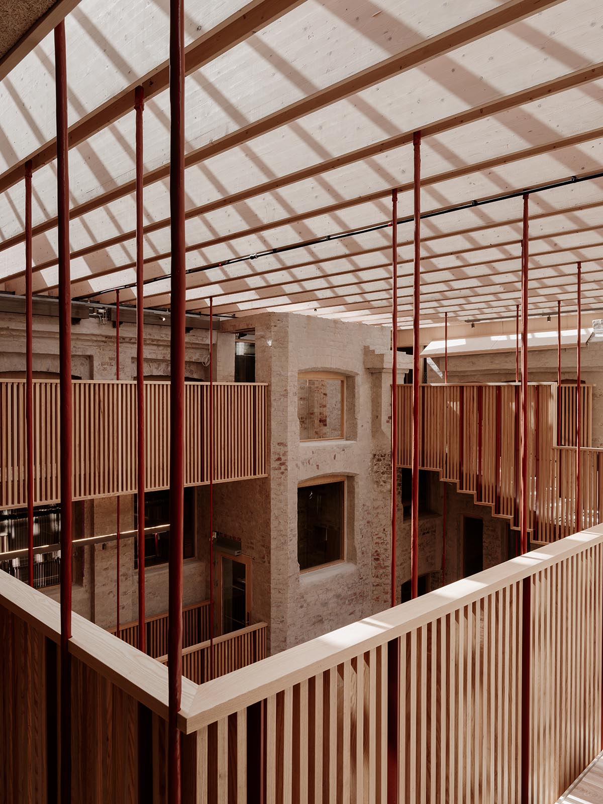 Atelier Oslo and KIMA Arkitektur restore former warehouse as a press house with light-lit atrium