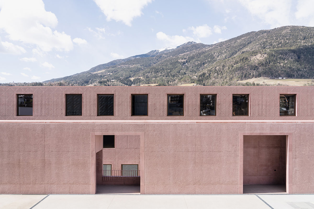 Carlana Mezzalira Pentimalli built music school with cut out and red-pigmented volumes in Italy