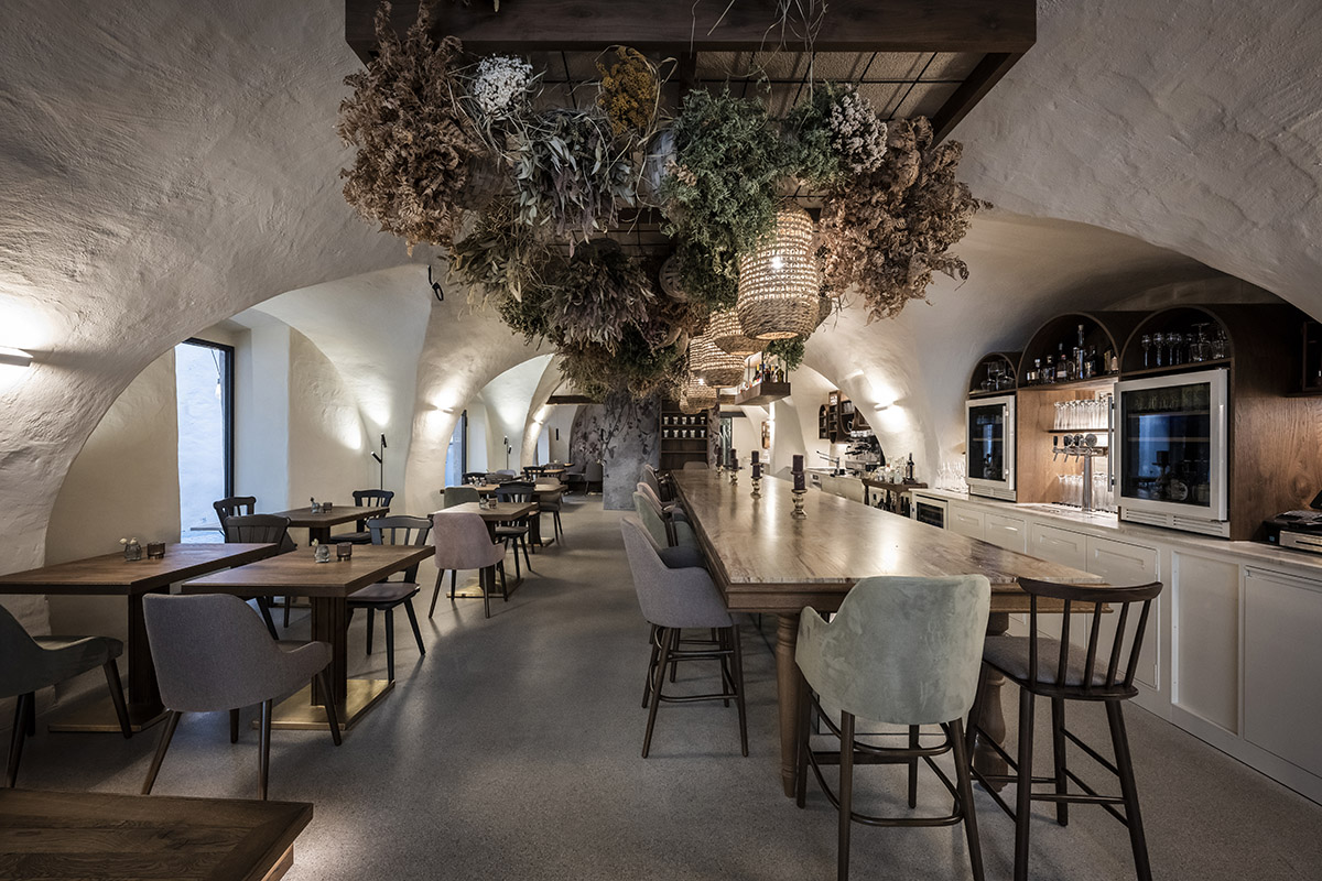 noa* transforms 19th-century workshop house into bohemian-style bistro with deep alcoves in Italy