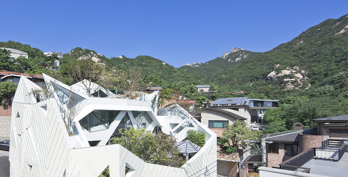 HyoMan Kim sets this polyhedron house on Bukhansan mountaintop to create climbable white petal