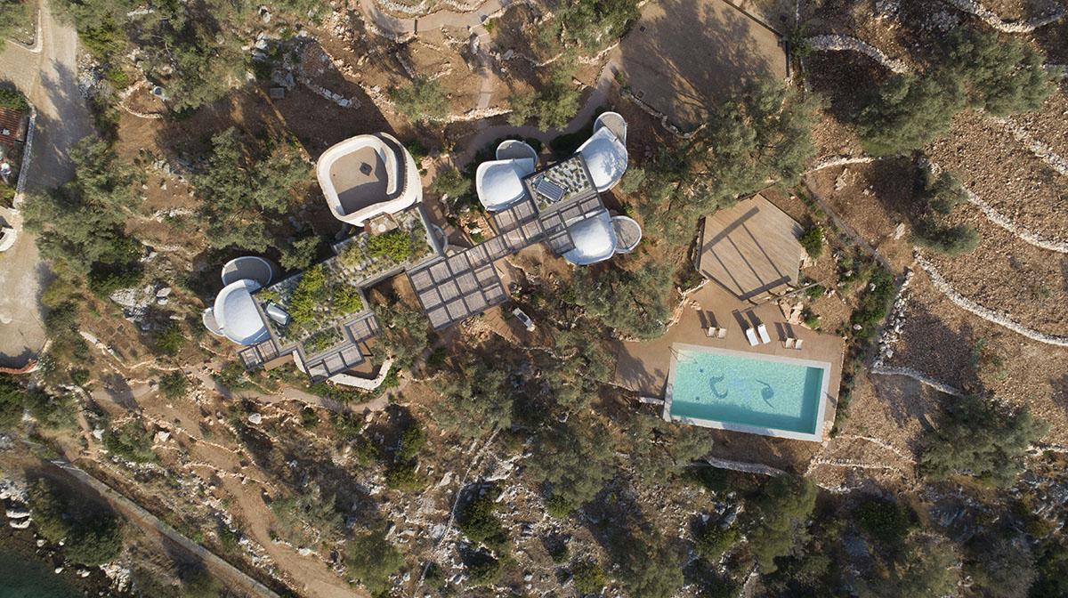 Pastoral round stone dwellings inform Meganisi House by Hiboux Architecture on Meganisi island