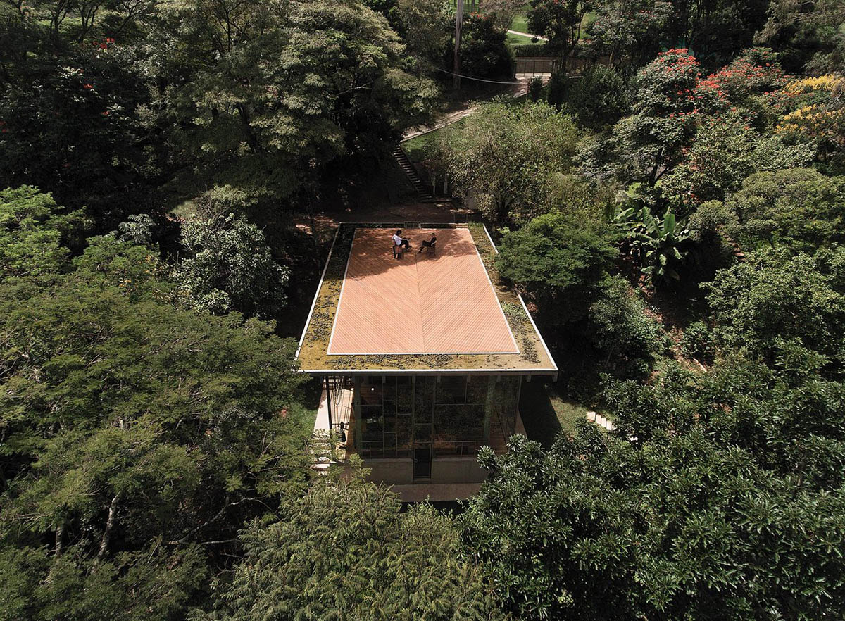Two bold concrete platforms define this transparent library house by Atelier Branco Arquitetura