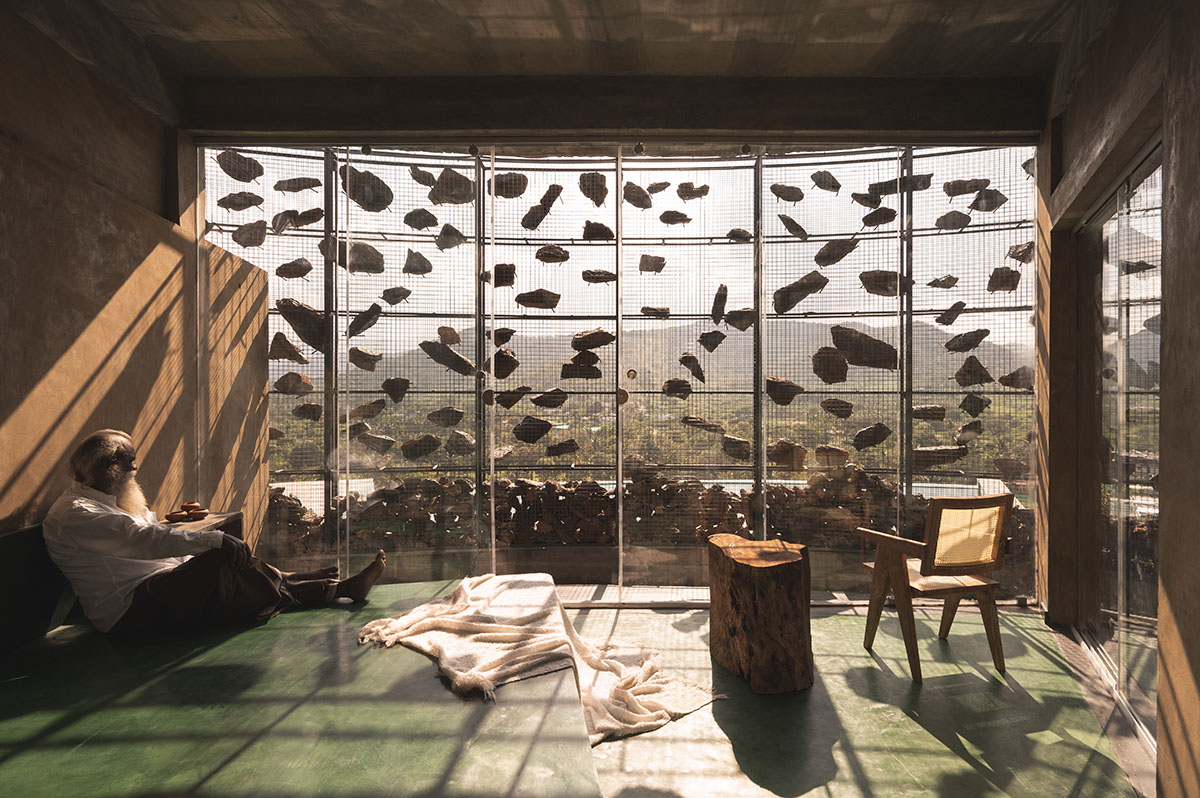 Farm house by Earthscape Studio is wrapped by gabion wall to filter light and airflow in India 