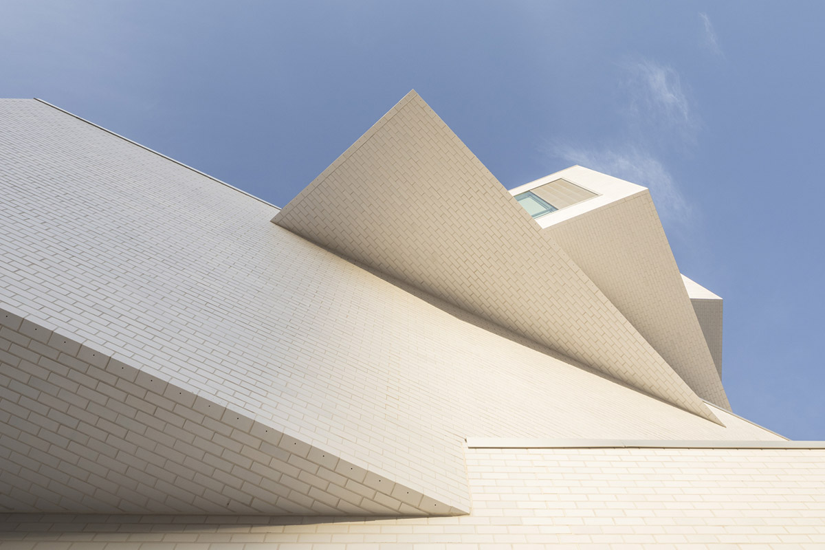 Five rectangular volumes rotating around a fixed pivot point form BIG-designed educational building